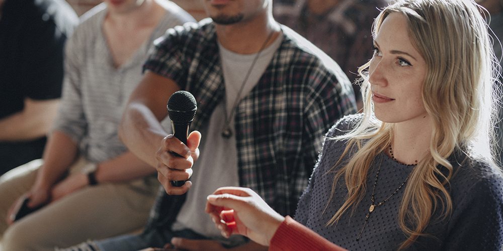 Man handing a microphone to a woman